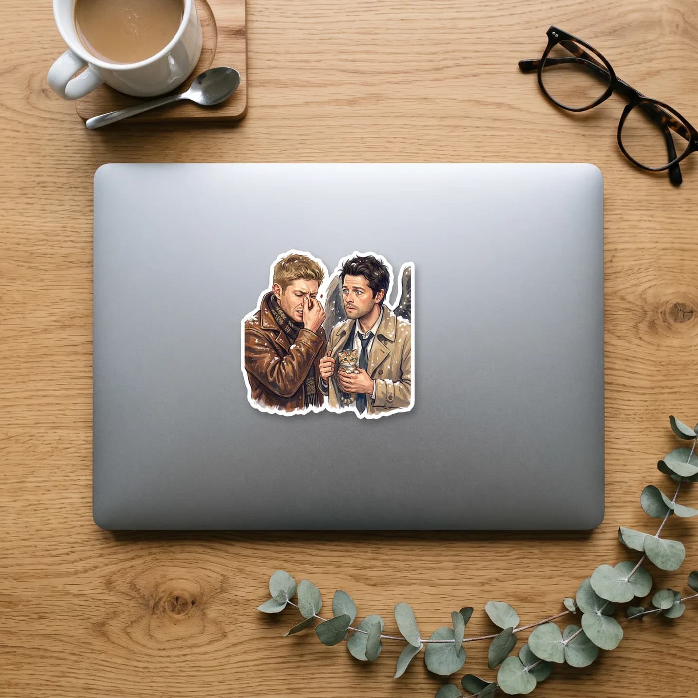Castiel holds up a tiny rescued kitten from the snowy cold while Dean looks on with fond resignation., view 2