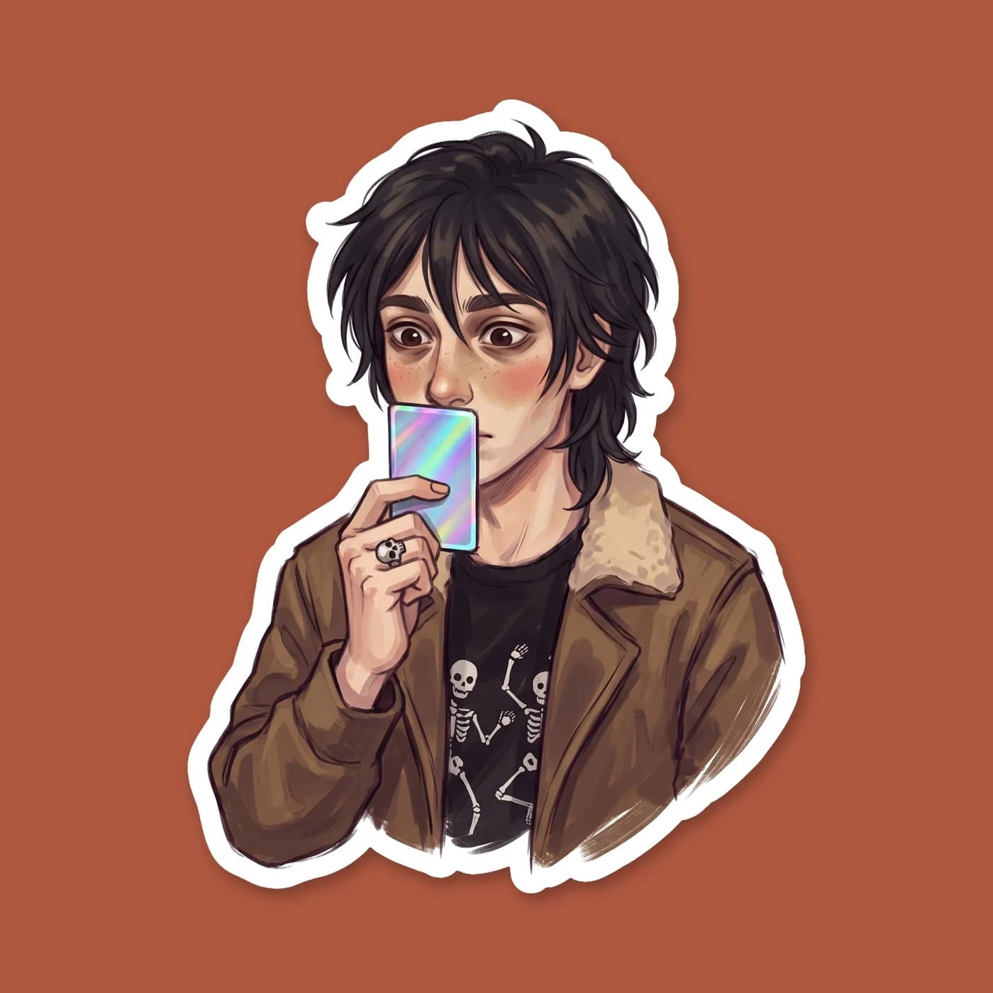 A younger Nico holds up a rare holographic Mythomagic card with quiet reverence. His oversized jacket hangs off his shoulders as he inspects the game stats., view 2